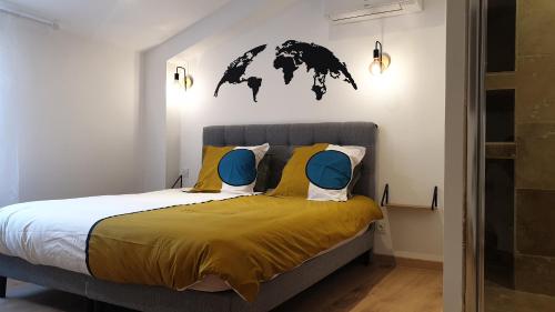 - une chambre avec un lit doté d'oreillers jaunes et bleus dans l'établissement Superbe Maison 68m2 avec Cour -Hypercentre Avignon, à Avignon