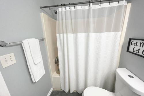 La salle de bains est pourvue d'un rideau de douche et de toilettes. dans l'établissement Stone Mountain's Hidden Secret, à Stone Mountain