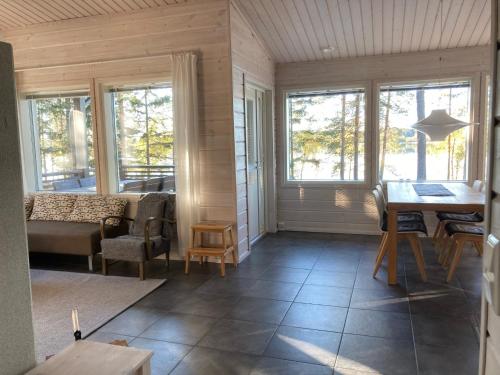 a living room with a table and chairs and windows at Puikkari Raijan Aitta in Mikkeli