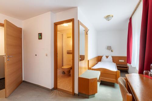 a small room with a bed and a mirror at Hotel Garni Traube in Friedrichshafen
