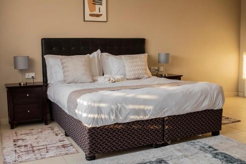 una camera da letto con un grande letto con due comodini di Pahotela Bed and Breakfast a Palapye