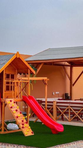 a playground with a slide in front of a house at شاليه الخفجي in Al Khafji
