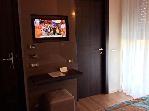 a hotel room with a television on the wall at Hotel Ariston & Apartments in Varazze