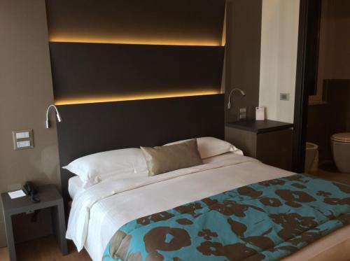 a bedroom with a large bed with a black headboard at Hotel Ariston & Apartments in Varazze