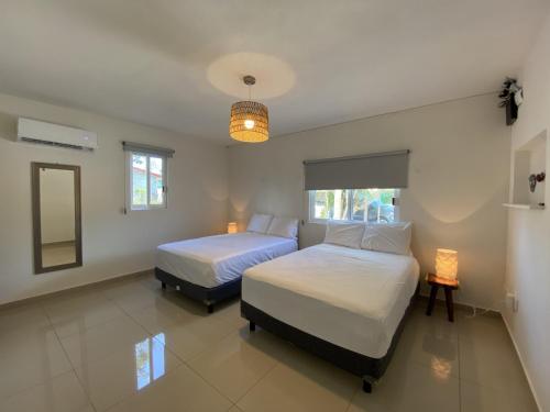 a bedroom with two beds and a mirror at Casa Colibrí El Cuyo in El Cuyo