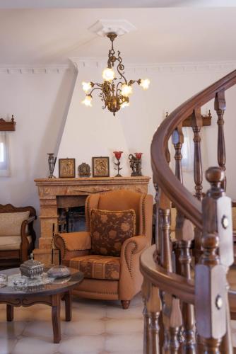 a living room with a chair and a chandelier at Castello di Haria in Kaloú