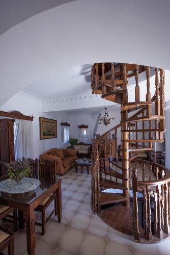 a living room with a spiral staircase in a house at Castello di Haria in Kaloú