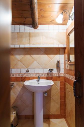 a bathroom with a white sink and a mirror at Castello di Haria in Kaloú