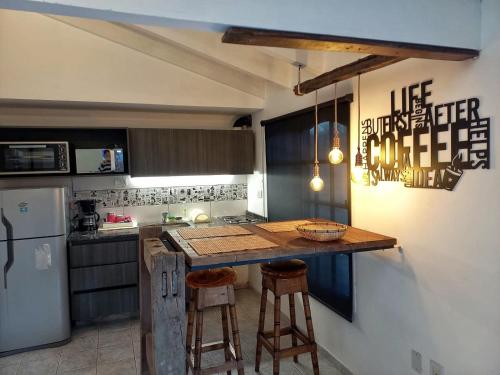 a kitchen with a counter with stools and a refrigerator at H125 - Complejo Mendoza in Mendoza