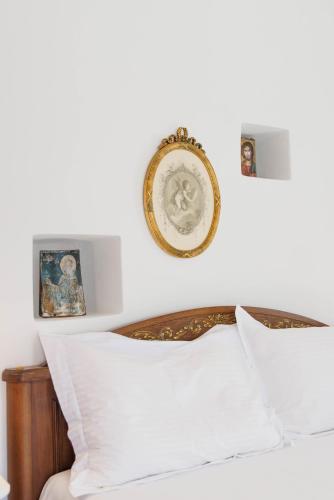 a bedroom with a bed and a clock on the wall at Castello di Haria in Kaloú