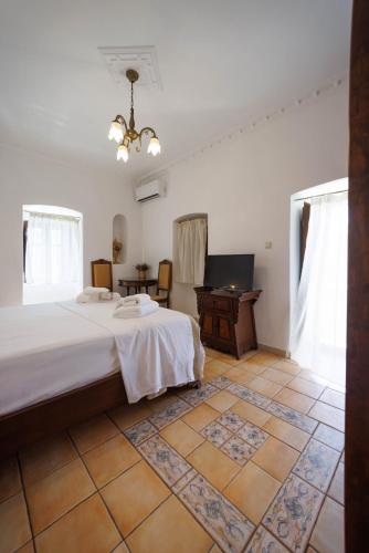 a bedroom with a bed and a desk in a room at Castello di Haria in Kaloú
