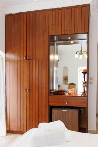 a bedroom with a large wooden cabinet with a mirror at Castello di Haria in Kaloú