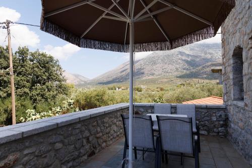 a patio with a table and chairs under an umbrella at Castello di Haria in Kaloú