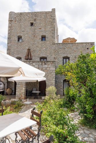 a building with tables and umbrellas in front of it at Castello di Haria in Kaloú