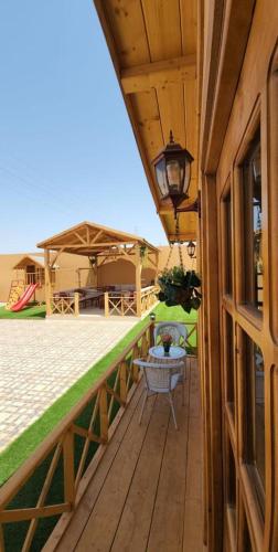 a wooden deck with a table and a lamp at شاليه الخفجي in Al Khafji