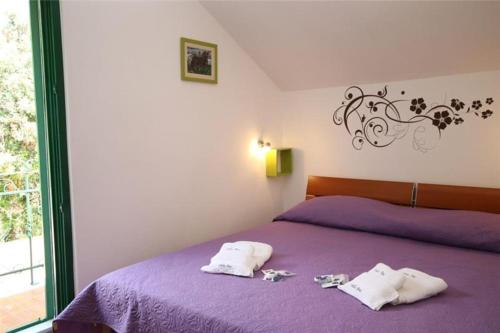 ein Schlafzimmer mit zwei Handtüchern auf einem lila Bett in der Unterkunft Villa Ana in Sevid