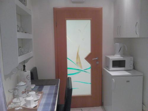 a kitchen with a door with a painting on it at Room Sarah in Rijeka