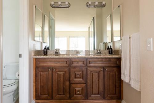 a bathroom with two sinks and two mirrors at Sonrisa I by AvantStay Bright Pacific Beach Home in San Diego