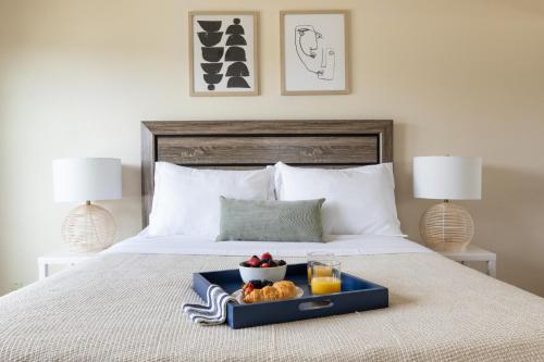 a tray of food on a bed with two lamps at Sonrisa I by AvantStay Bright Pacific Beach Home in San Diego