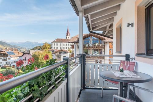 a balcony with a table and a view of a city at Superior Apartments Marialisa Tulpe in Chiusa