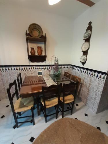 a dining room with a wooden table and chairs at Casa Rincón in Iznatoraf