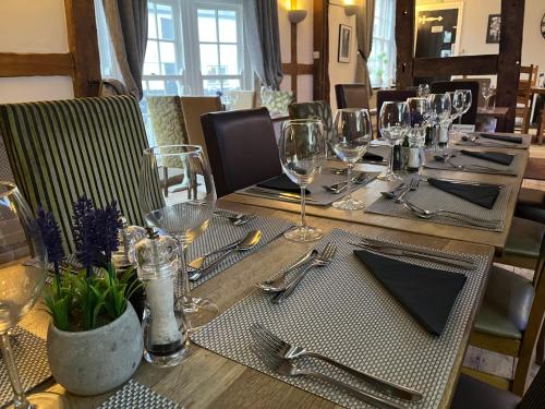 a long wooden table with glasses and silverware on it at The Swan Hotel in Kington