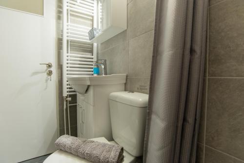 a bathroom with a toilet and a shower curtain at Comfy Sweet Home in Athens