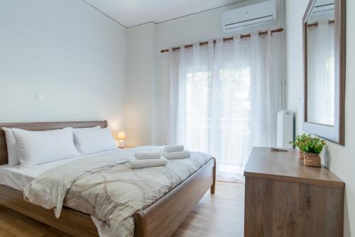 a white bedroom with a large bed and a window at Comfy Sweet Home in Athens