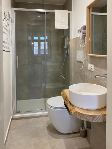 a bathroom with a shower and a toilet and a sink at Liotru Maisonne, rooms with en-suite bathroom and shared bathroom in Catania
