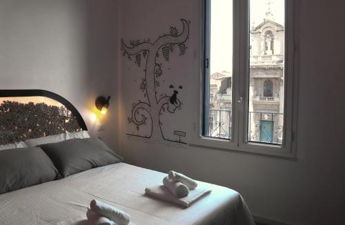 a bedroom with a bed with two stuffed animals on it at Liotru Maisonne, rooms with en-suite bathroom and shared bathroom in Catania