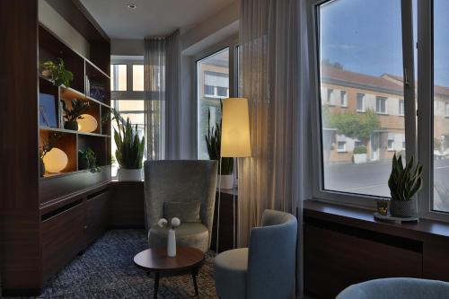 a living room with a chair and a window at City Partner Hotel Lenz in Fulda