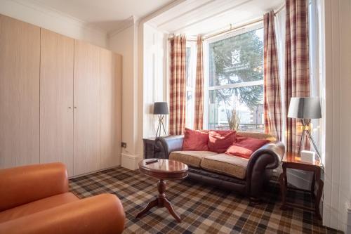 Gordonston Apartments في إينفيرنيس: غرفة معيشة مع أريكة ونافذة