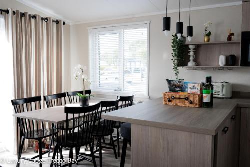 a kitchen with a table with chairs and a dining room at Holiday Lodge 6 in Porthcawl