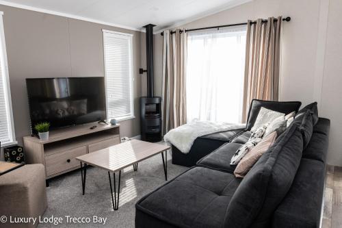 uma sala de estar com um sofá e uma mesa em Holiday Lodge 6 em Porthcawl