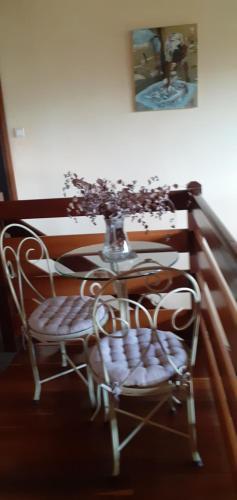 a table with a vase of flowers on top of it at Chambre d'Hôte Villa Maritampona in Antsirabe