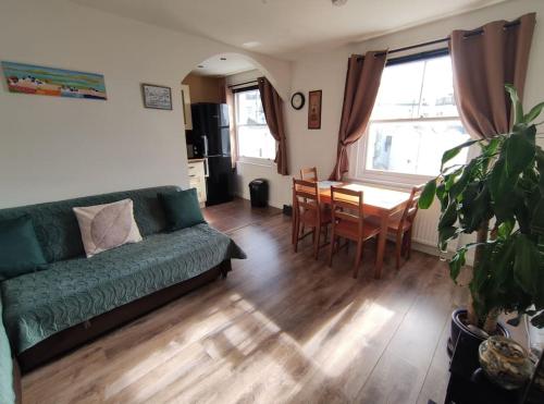 a living room with a green couch and a table at Lovely & bright 1 bedroom apartment near the beach in Brighton & Hove