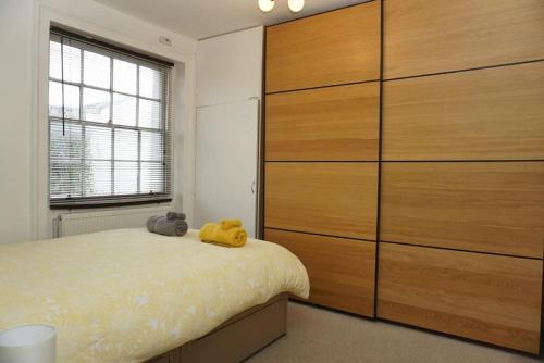 a bedroom with a large wooden dresser and a bed at Lovely & bright 1 bedroom apartment near the beach in Brighton & Hove