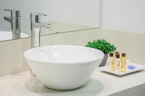 - un lavabo blanc sur un comptoir dans la salle de bains dans l'établissement Apartamento completo - Vila A, à Foz do Iguaçu