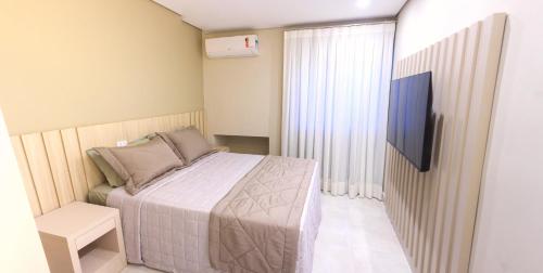 Dormitorio pequeño con cama y TV en Apartamento completo - Vila A, en Foz do Iguaçu