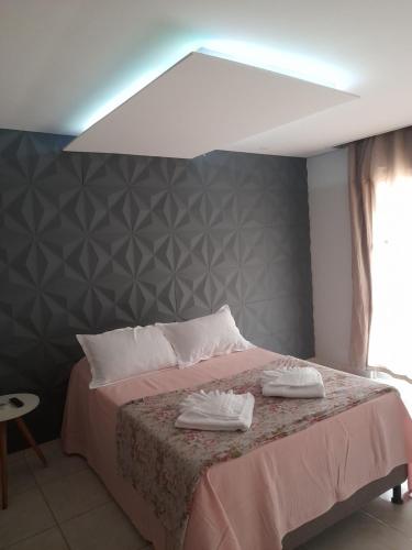 a bedroom with a bed with two white towels on it at LUZ DO LUAR in Pedra Azul