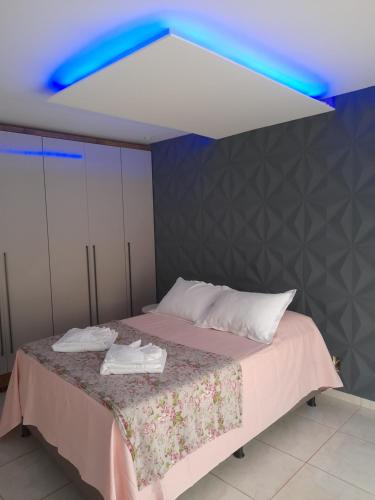 a room with a bed with a blue light at LUZ DO LUAR in Pedra Azul