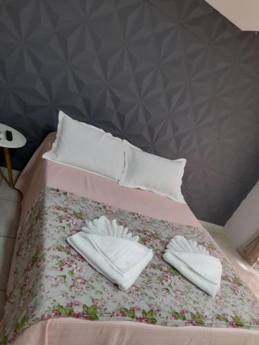 a bed with two white towels on top of it at LUZ DO LUAR in Pedra Azul