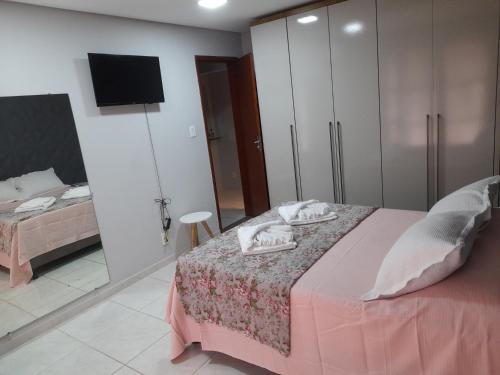 a bedroom with a bed and a tv on a wall at LUZ DO LUAR in Pedra Azul