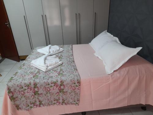 a pink bed with towels and pillows on it at LUZ DO LUAR in Pedra Azul