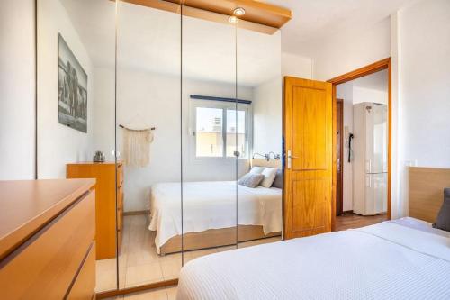 um quarto com uma cama e uma parede espelhada em Fabuloso ático, con amplia terraza em El Médano