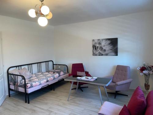 sala de estar con cama, mesa y sofá en Srní- Červený byt/ dvojdomek u hotelu Vydra, en Srní