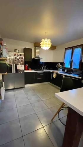 Il comprend une cuisine équipée d'un réfrigérateur et d'une table avec des chaises. dans l'établissement Maison au cœur de luz sauveur, à Luz-Saint-Sauveur