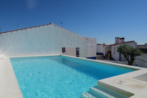 a large blue swimming pool next to a building at A Janela do Alentejo in Campinho