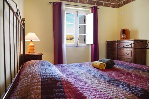 a bedroom with a bed and a window at A Janela do Alentejo in Campinho