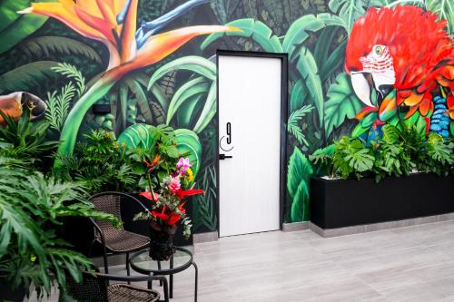 庫庫塔的住宿－Hotel Casa Luna，一间装饰有植物壁画的房间和一扇门